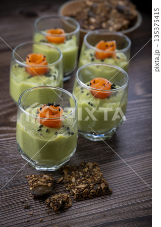 Smoked salmon shot glasses guacamole served with homemade crackers 135375415