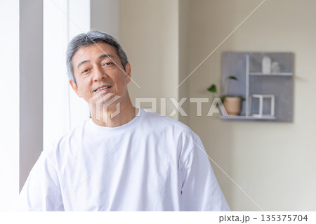 窓辺に立つシニア男性 135375704