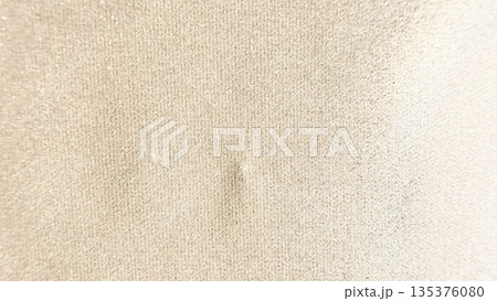 soft beige fabric texture closeup with subtle central dent and grainy weave evoking calm neutrality for wallpaper or banner background soft beige fabric texture closeup with subtle central dent and grainy weave evoking calm neutrality for wallpaper or banner background 135376080