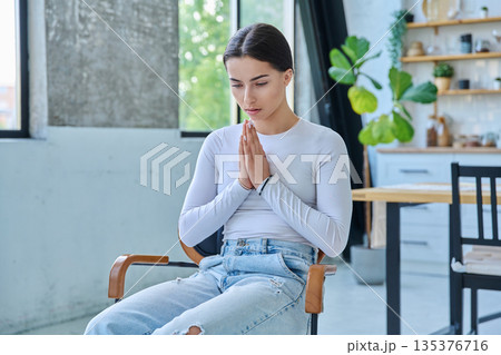 Sad upset teenager girl sitting at home in living room 135376716
