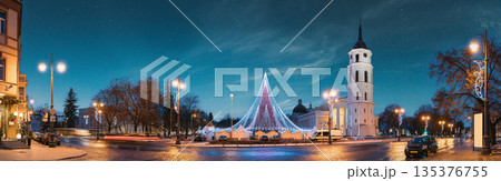 Vilnius, Lithuania. Christmas Tree On Background Bell Tower Belfry Of Vilnius Cathedral At Cathedral Square In Evening New Year Christmas Xmas Illuminations. Unesco World Heritage Site Vilnius, Lithuania. Christmas Tree On Background Bell Tower Belfry Of Vilnius Cathedral At Cathedral Square In Evening New Year Christmas Xmas Illuminations. Unesco World Heritage Site 135376755