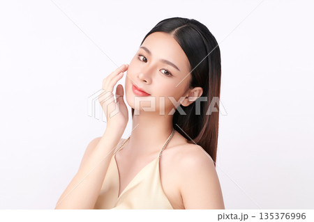A beautiful young Asian woman with clean, fresh skin against a white background. Skincare, facial treatment, cosmetology, beauty, and spa. An elegant portrait of an Asian woman. 135376996