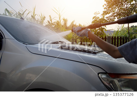 Washing a car with a high-pressure washer. Washing a car with a high-pressure washer. 135377126