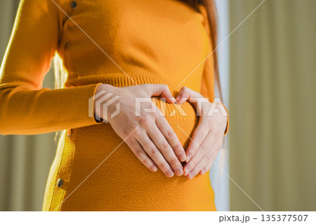 Pregnancy motherhood expectation future. Pregnant woman hands touching big belly. Girl making heart shape with hands enjoying pregnancy. Pregnant woman showing heart sign. Maternity love new life 135377507