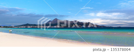 Puerto pollensa beach panorama with distant mountains and clear water 135378004
