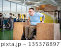 Dedicated disabled man with spinal injury working on arms and upper body strength on wooden blocks. 135378897