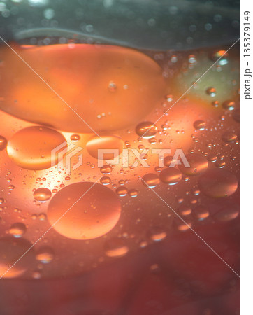 Vibrant Red Oil Drop Floating In Water Vibrant Red Oil Drop Floating In Water 135379149