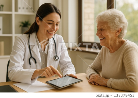 Doctor consulting elderly patient with tablet in clinic 135379453