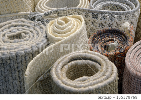 Group of assorted carpets and rugs of various sizes and colors, rolled 135379769