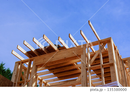 Workers build wooden frame structure with beams under assembly together new house Workers build wooden frame structure with beams under assembly together new house 135380000