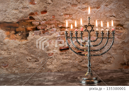 Celebrating menorah stands with lit candles Jewish holiday festive celebrating spirit of Hanukkah. Celebrating menorah stands with lit candles Jewish holiday festive celebrating spirit of Hanukkah. 135380001