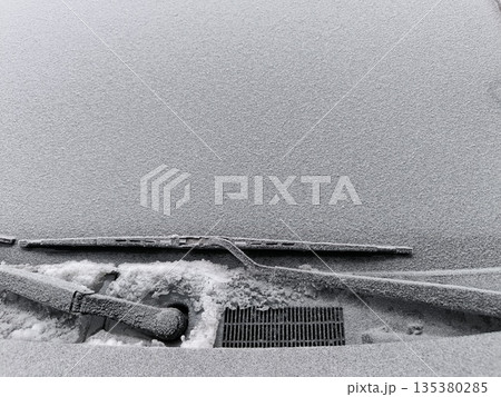Frost-covered frozen car windshield, frozen wiper blades Frost-covered frozen car windshield, frozen wiper blades 135380285