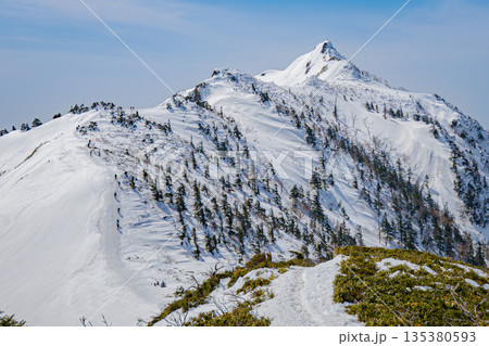 雪山の稜線を行く登山者｜快晴の冬山縦走風景 135380593