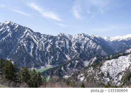 雪残る山脈と渓谷に広がるエメラルドの湖 雪残る山脈と渓谷に広がるエメラルドの湖 135380604