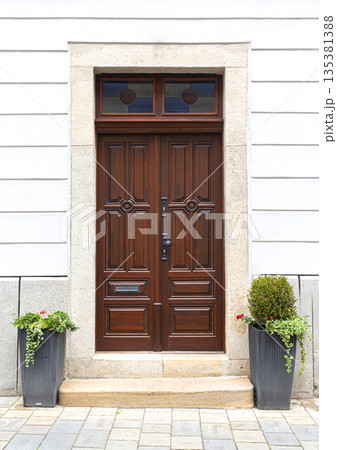 Ornate double wooden door inviting home entrance Ornate double wooden door inviting home entrance 135381388