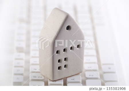 Small house on white computer keyboard 135381906