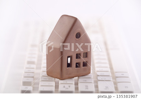 Small house on white computer keyboard 135381907
