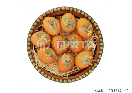 Easter eggs decorated with dried flowers in ceramic plate. Isolate on a white background. Easter traditions. Variety of homemade foods. Country style. 135382145