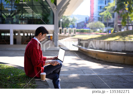 Professional man using mockup laptop with empty screen a serene outdoor setting 135382271