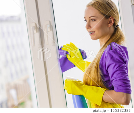 Girl cleaning window at home Girl cleaning window at home 135382385