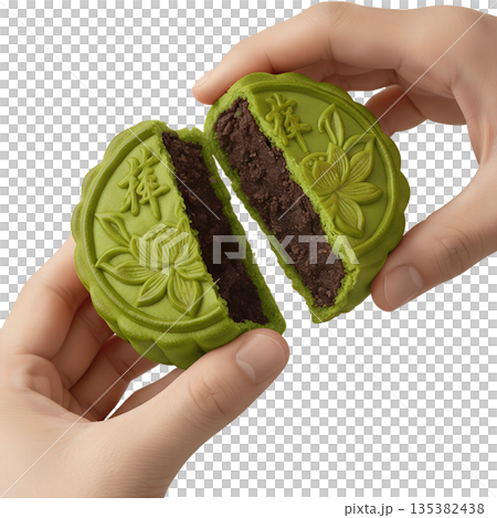 Hand breaking apart matcha mooncake with lotus seed paste, symbolizing family reunion and the harvest moon celebration 135382438
