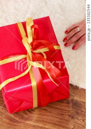Female hands with red gift box Female hands with red gift box 135382544