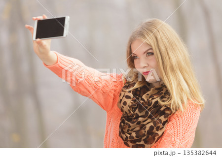 Happy fashion woman in park taking selfie photo. 135382644