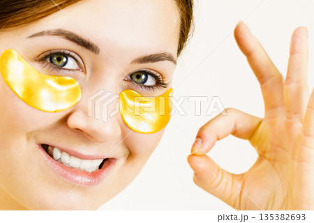 Woman with gold patches under eyes Woman with gold patches under eyes 135382693