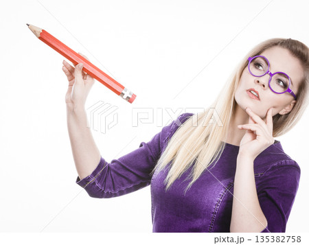 Woman confused thinking, big pencil in hand 135382758