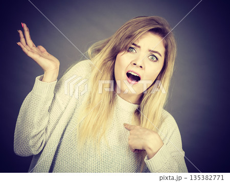Confused young blonde woman gesturing with hands Confused young blonde woman gesturing with hands 135382771