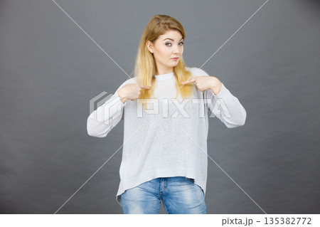 Confused woman pointing at herself Confused woman pointing at herself 135382772