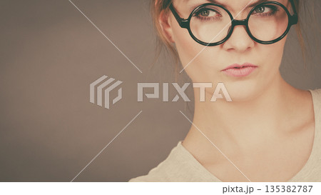 Bored focused teenage woman wearing eyeglasses 135382787