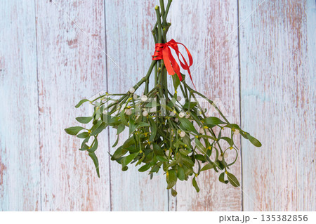 photo of a mistletoe bouquet with a red ribbon photo of a mistletoe bouquet with a red ribbon 135382856