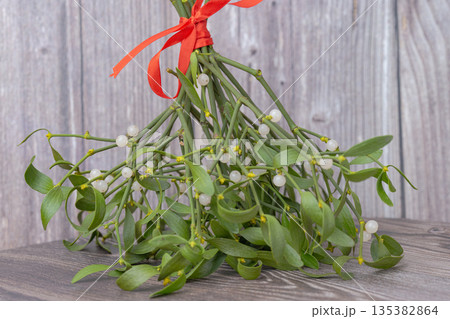photo of a mistletoe bouquet with a red ribbon photo of a mistletoe bouquet with a red ribbon 135382864