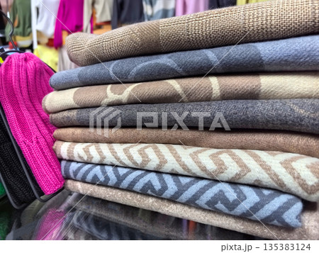 Colorful textiles display in a vibrant market stall during sunny afternoon Colorful textiles display in a vibrant market stall during sunny afternoon 135383124
