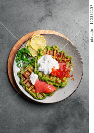 Healthy low carb breakfast with green avocado waffles, salmon, red caviar, soft cheese 135383157