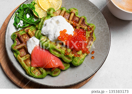 Healthy low carb breakfast with green avocado waffles, salmon, red caviar, ricotta cheese Healthy low carb breakfast with green avocado waffles, salmon, red caviar, ricotta cheese 135383173