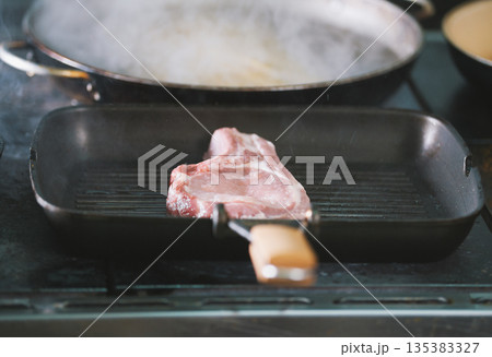 The raw meat on the grill cooked in restaurant 135383327