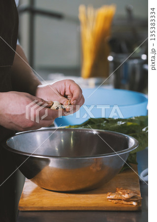 Chef cleans quail egg in a salad bowl in the restaurant 135383334