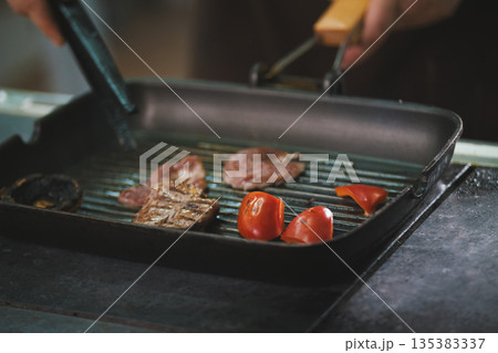 chef is frying meat and vegetables in a pan chef is frying meat and vegetables in a pan 135383337