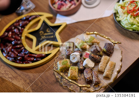 Family enjoys iftar in a restaurant with Ramadan decorations Family enjoys iftar in a restaurant with Ramadan decorations 135384191