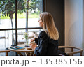 Pondering relaxed businesswoman sitting at cafe looking at window and thinking about work plans. 135385156