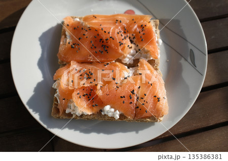 Gourmet salmon dish featuring smoked or raw cuts with toast or rice. Gourmet salmon dish featuring smoked or raw cuts with toast or rice. 135386381