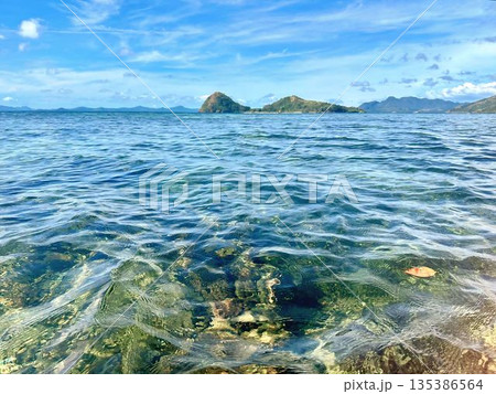 Crystal clear turquoise ocean water with distant tropical islands in the Philippines Crystal clear turquoise ocean water with distant tropical islands in the Philippines 135386564