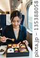 新幹線とお弁当を食べる女性 135388058