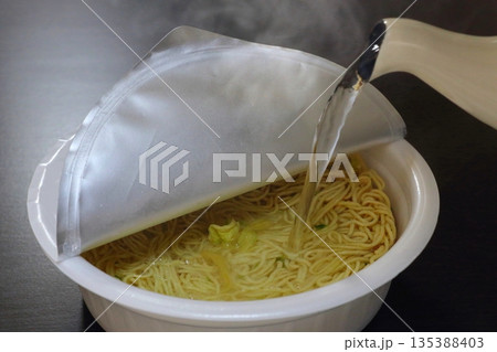 カップ焼きそばに湯を注ぐ カップ焼きそばに湯を注ぐ 135388403