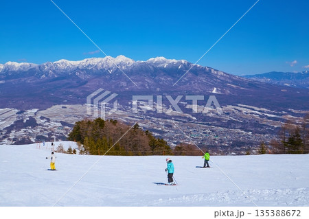 冬の長野県富士見町の富士見パノラマリゾートのゴンドラ山頂駅付近から八ヶ岳連峰のパノラマ風景とスキーヤ 135388672