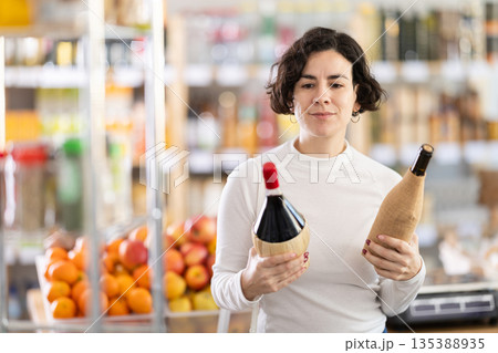 Adult woman choosing wine in grocery store 135388935