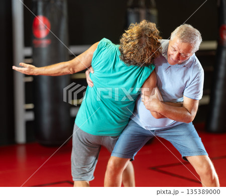 Male pupil clash with training manager during self-defense lesson, repulse charge, intensity of practice 135389000