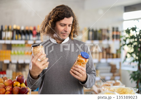 Man choosing cans of beans 135389023